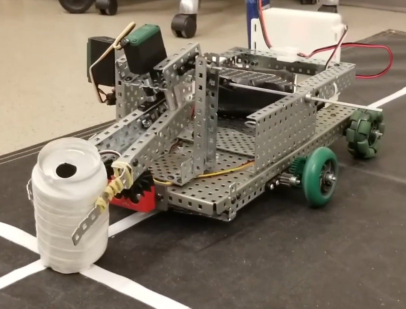 Wheeled robot with a metal frame and a front mechanism for interacting with objects